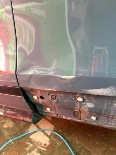 Complicated dent on skirt of vehicle
